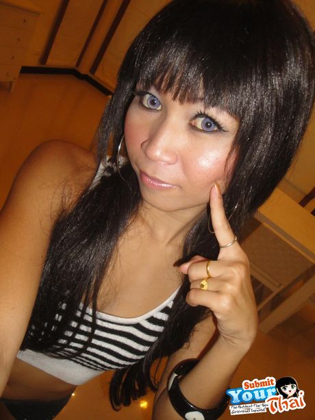 Asiatisk babe amatørpige bliver nøgen i stribede sokker på en seng