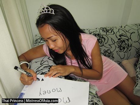 アジア人の女の子、タイの王女がドレスを脱いでピンクのドレスでポーズをとる