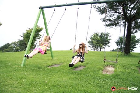 サングラスをかけた金髪のカバーガールたちが野原の毛布の上で裸になる