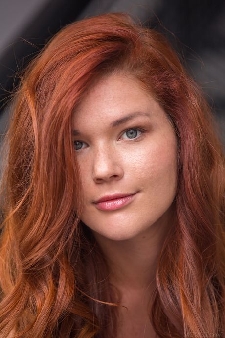 性感紅髮女郎米婭·索利斯穿著靴子，肚臍上有穿孔，裸體擺造型