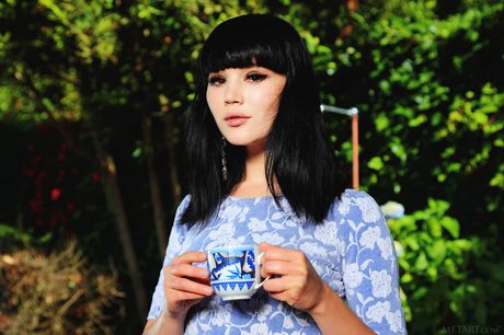 Den forførende teenager Malena tager sin blå kjole og strømper af for at posere nøgen i haven