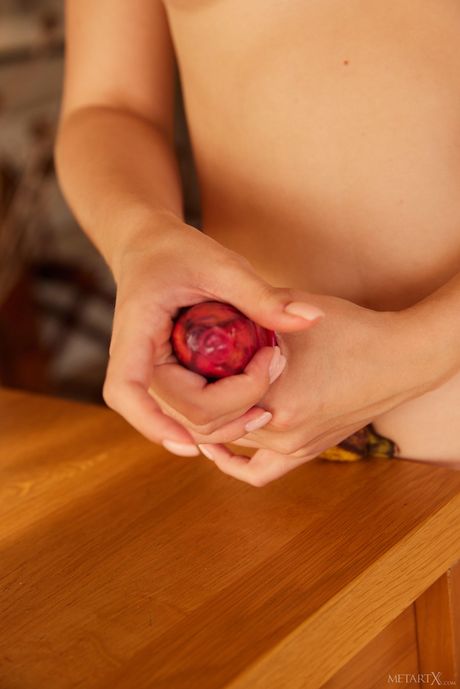 美しいロシアのブロンドのリリー・ブロッサムはバッグからバナナを取り出し、赤いコンドームを巻く