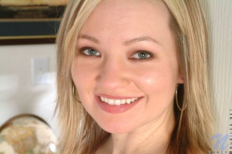 淺色頭髮的封面女郎特蕾西露出了她毛茸茸的陰部並將其攤在椅子上