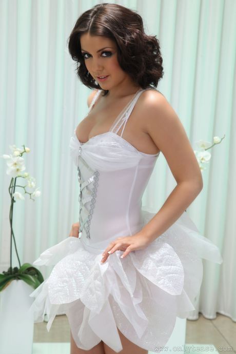 Dark haired teen Bryoni Kate removes a white dress to model in the nude