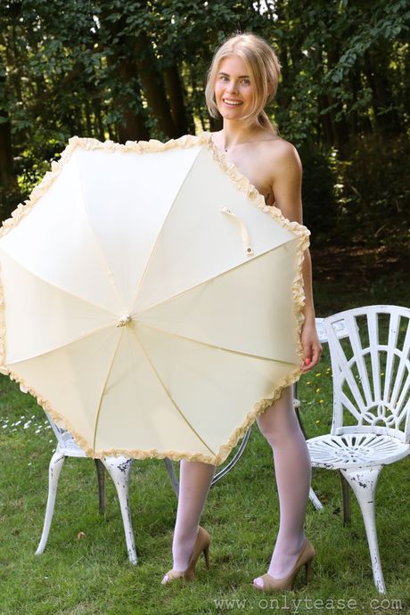 Blonde british girl Tayla demonstrates her petite small tits and ass in a garden