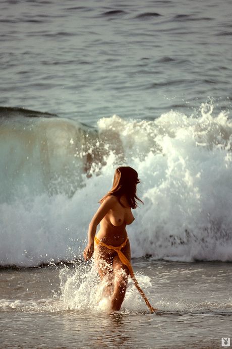 魅力的なアメリカ人の黒髪のパティ・マグワイアがハイヒールを履いてベッドの上で裸になる