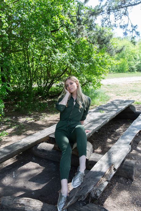 Tynd blond teenager Varvara modellerer helt nøgen på en træbænk ved en bæk