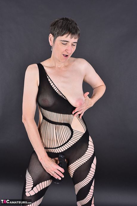 Fremragende tysk moden dame i latex leger med sin barberede fisse i fiskenet