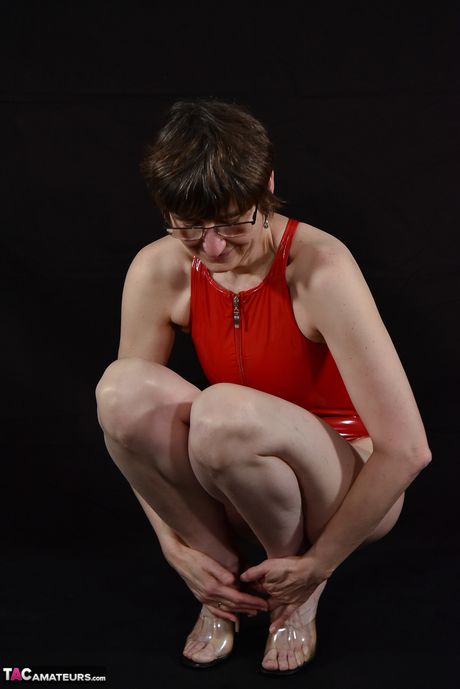 成熟したドイツの黒髪の赤いランジェリーのホットな熟女がソロでポーズをとる