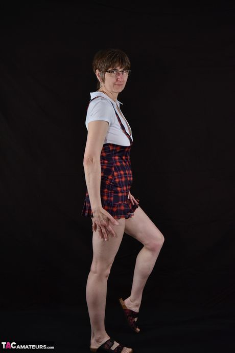 Moden tysk dame med briller og ternet nederdel strimler ned til hælene