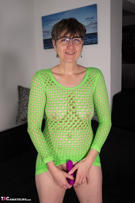 Moden tysk dame Lila leger sin fisse med en lilla dildo i en grøn kjole