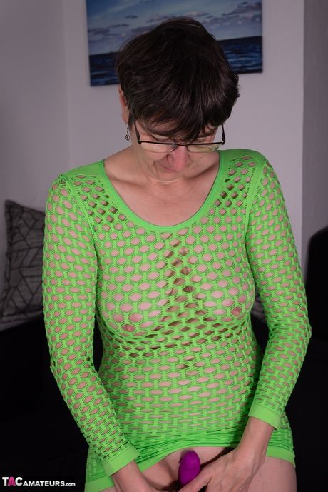 Moden tysk dame Lila leger sin fisse med en lilla dildo i en grøn kjole