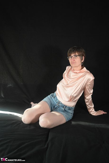 戴眼鏡的瘦熟女脫光衣服，露出長襪，炫耀她的陰毛