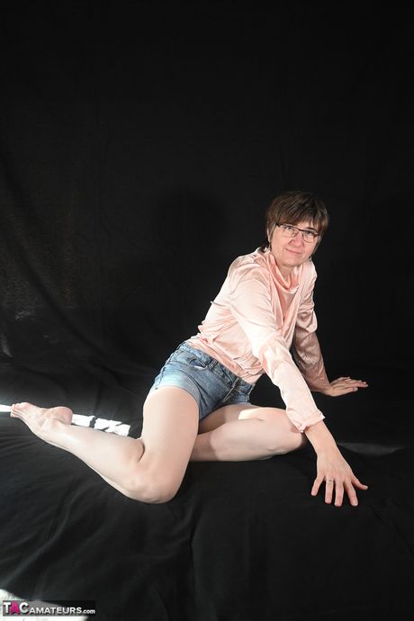 戴眼鏡的瘦熟女脫光衣服，露出長襪，炫耀她的陰毛