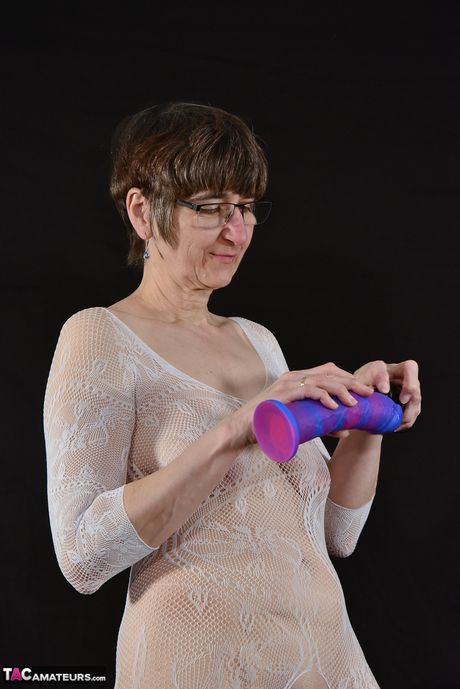 Moden tysk dame med briller og fiskenet leger med sin fisse på kontoret