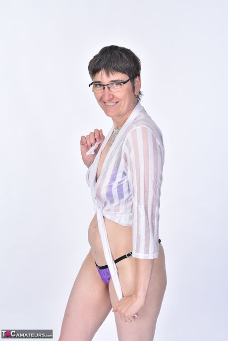 Moden tysk brunette Lila Hebe stripper ned til sine briller og hæle i en solo