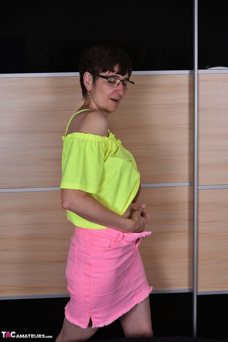 Moden tysk dame med briller og strømper stripper til hendes strømper