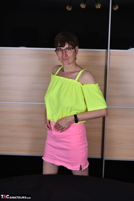 Moden tysk dame med briller og strømper stripper til hendes strømper