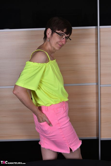 Moden tysk dame med briller og strømper stripper til hendes strømper