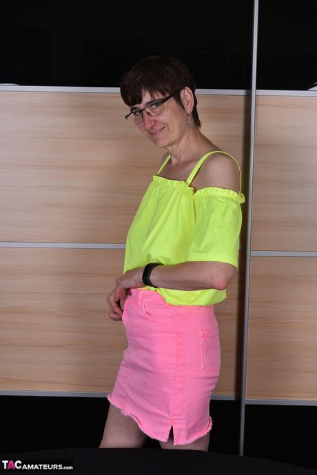 Moden tysk dame med briller og strømper stripper til hendes strømper