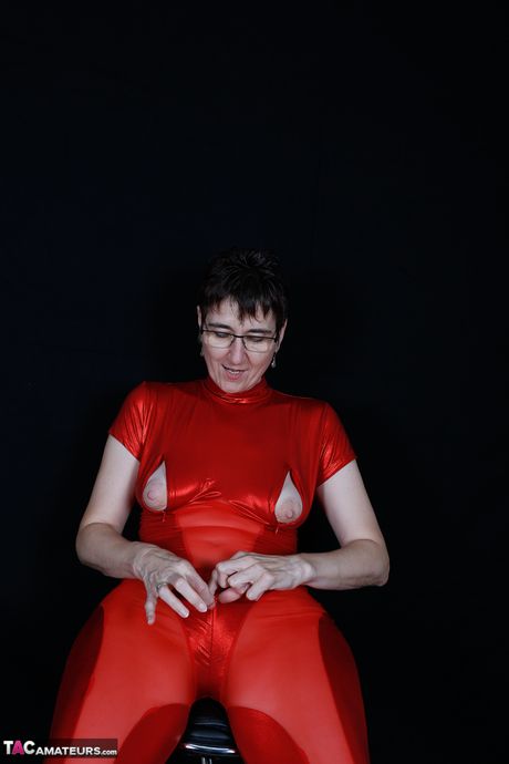 Moden tysk dame i rødt lingeri og høje hæle stripper og onanerer