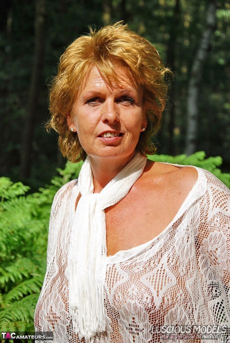 Lyshåret amatør moden dame M stripper og viser sine store bryster udendørs