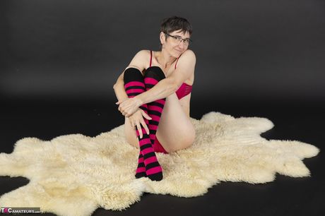 戴眼鏡的瘦熟女脫下襪子並玩弄她的陰部