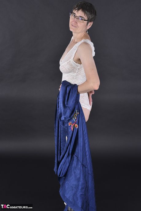 Smuk tysk moden dame i briller og strømper stripper til hvide trusser