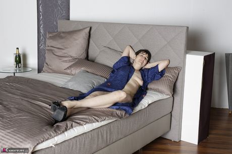 聰明的熟女是一位喜歡戴著眼鏡擺裸體姿勢的成熟女士