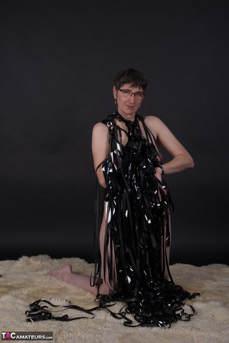 嬌小成熟女士戴眼鏡脫下衣服，露出嬌小的小乳房和光禿的陰部