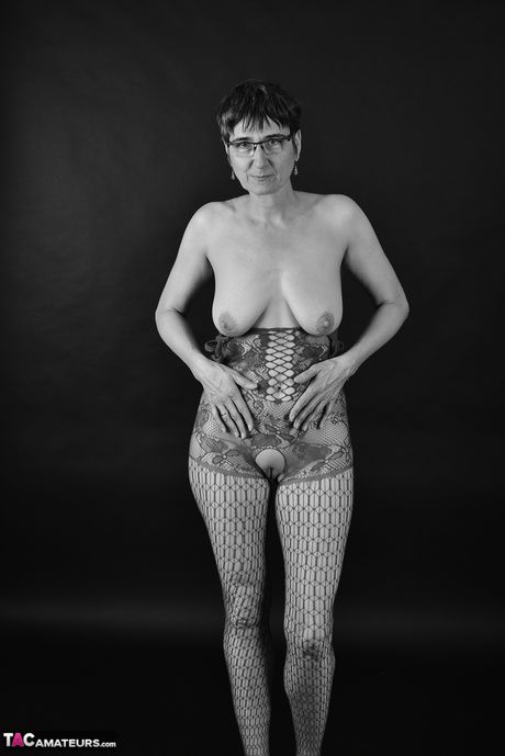 Moden tysk dame med briller stripper ned til sine strømper og hæle i en gang