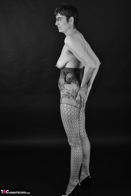 戴眼鏡的成熟德國女士在走廊上脫掉長襪和高跟鞋