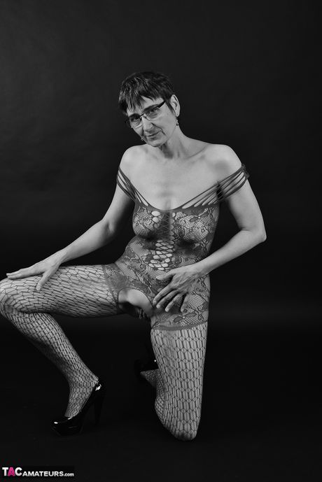 Voksen tysk dame i catsuit og briller stripper ned til hendes strømper