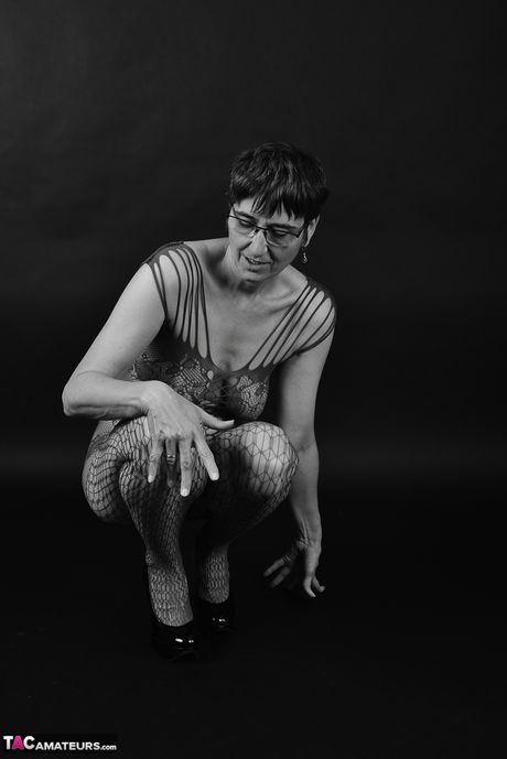 Voksen tysk dame i catsuit og briller stripper ned til hendes strømper