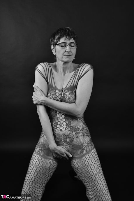 Voksen tysk dame i catsuit og briller stripper ned til hendes strømper