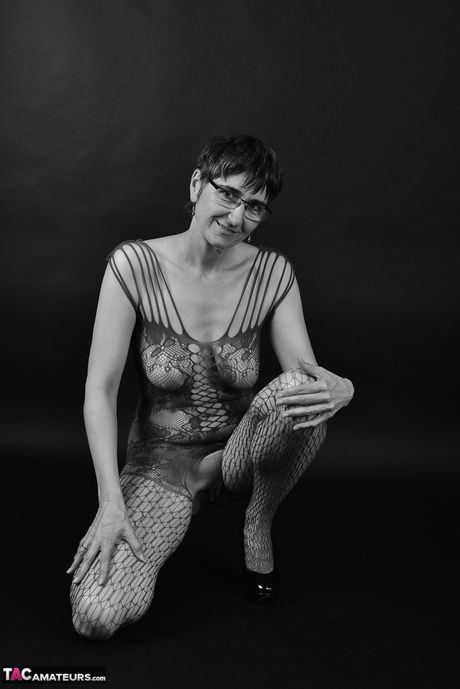 Voksen tysk dame i catsuit og briller stripper ned til hendes strømper