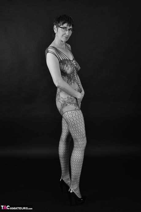 Voksen tysk dame i catsuit og briller stripper ned til hendes strømper