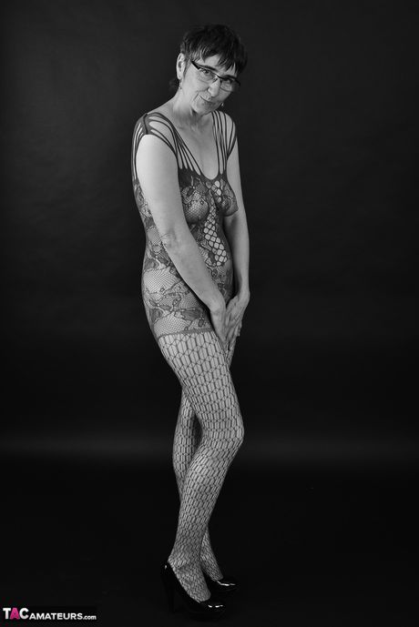 Voksen tysk dame i catsuit og briller stripper ned til hendes strømper