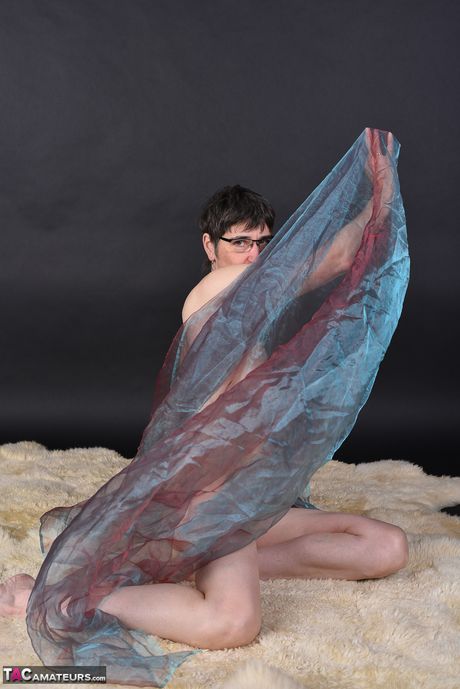 戴著眼鏡和長襪的苗條成熟女士脫光衣服