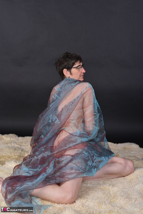 戴著眼鏡和長襪的苗條成熟女士脫光衣服