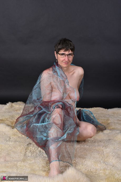 戴著眼鏡和長襪的苗條成熟女士脫光衣服