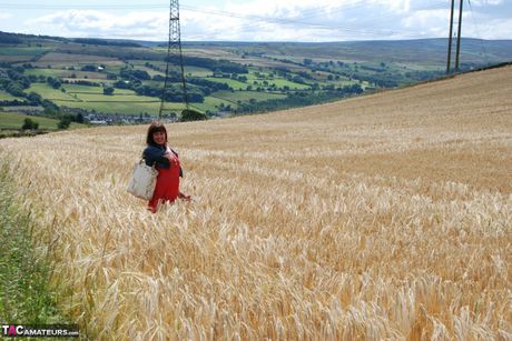 Mature british dark-haired Janey strips to her panties and fingers herself in the fields