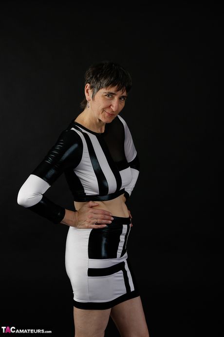 Sød moden dame i sort latex klæder sig af for at vise teenage bryster