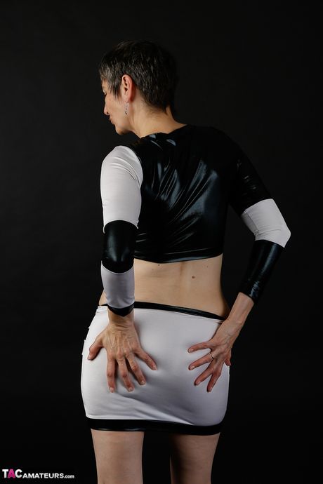 Sød moden dame i sort latex klæder sig af for at vise teenage bryster