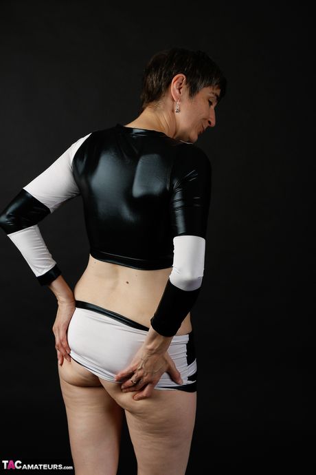 Sød moden dame i sort latex klæder sig af for at vise teenage bryster