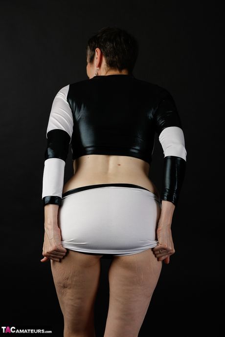 Sød moden dame i sort latex klæder sig af for at vise teenage bryster