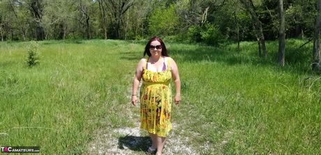 Amerikansk cougar med store bryster, sexet, bbw, stripper sit tøj og viser sit bare kød frem i parken