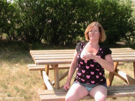 成熟したカナダ人の金髪ミシャ・ミルフが大きな胸を露出し、屋外でポーズをとる