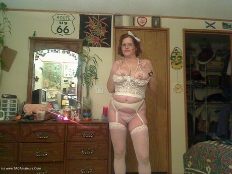 高齢のカナダ人女性、ミシャ・ミルフが素晴らしいおっぱいを披露し、白いストッキングでポーズをとる