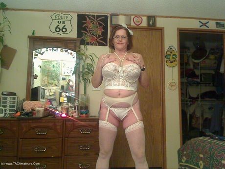 高齢のカナダ人女性、ミシャ・ミルフが素晴らしいおっぱいを披露し、白いストッキングでポーズをとる